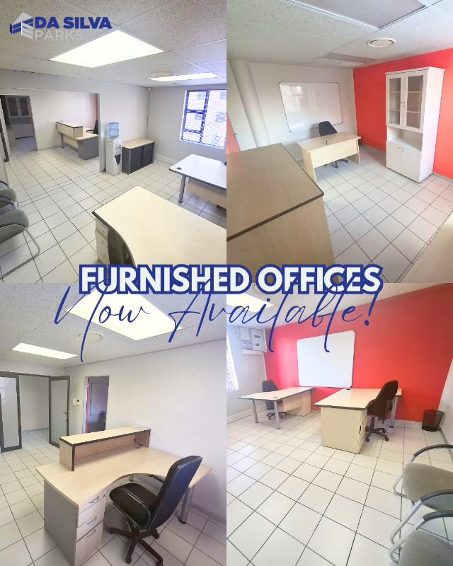 Interior view of furnished office space with desks and chairs in a bright setting.